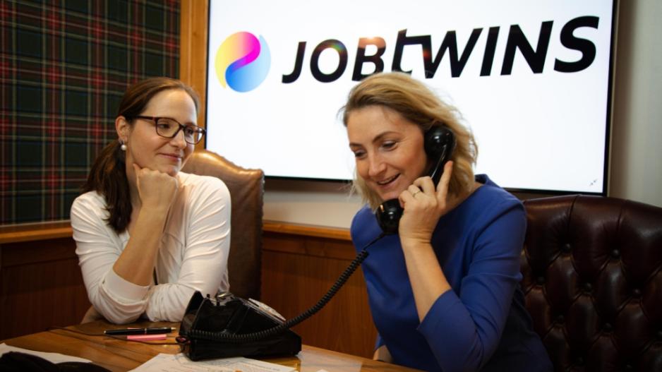 Zwei Frauen arbeiten im Büro, eine telefoniert